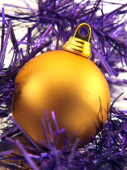 Golden christmas ornament in violet decorative ribbon
