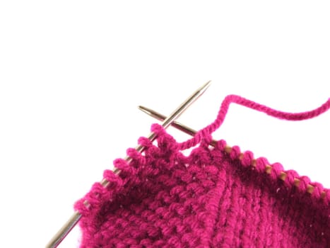 a pair of knitting needles and pink yarn