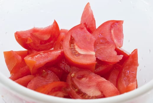 Slices of fresh tomato in white bowl