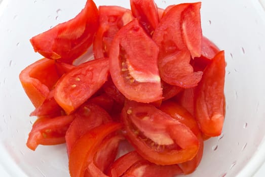 Slices of fresh tomato in white bowl