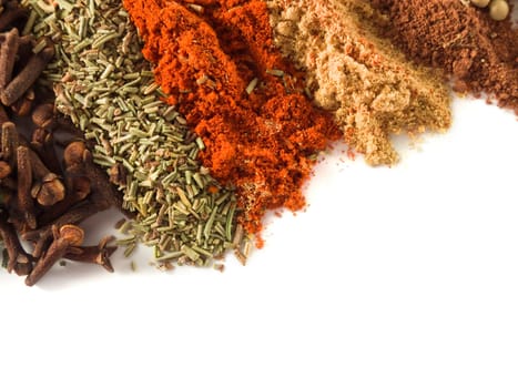 closeup of various spices over white