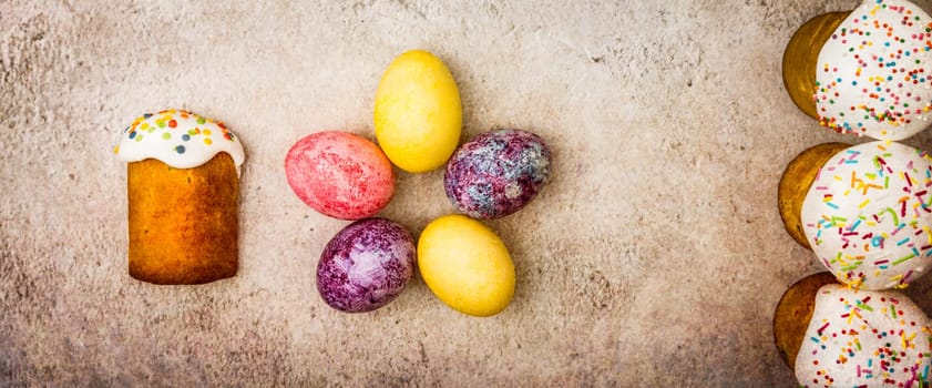 Easter cakes and Easter colored eggs on a beautiful textured background. Religious holiday of bright Easter.