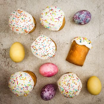 Easter cakes and Easter colored eggs on a beautiful textured background. Religious holiday of bright Easter.