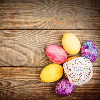 Easter cakes and Easter colored eggs on a wooden background. Religious holiday of bright Easter.