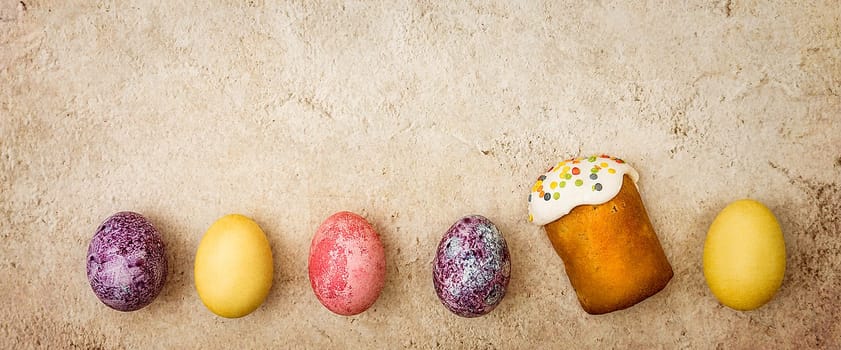 Easter cakes and Easter colored eggs on a beautiful textured background. Religious holiday of bright Easter.
