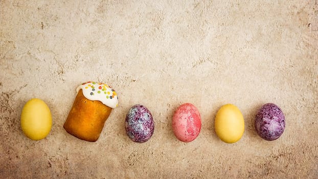 Easter cakes and Easter colored eggs on a beautiful textured background. Religious holiday of bright Easter.
