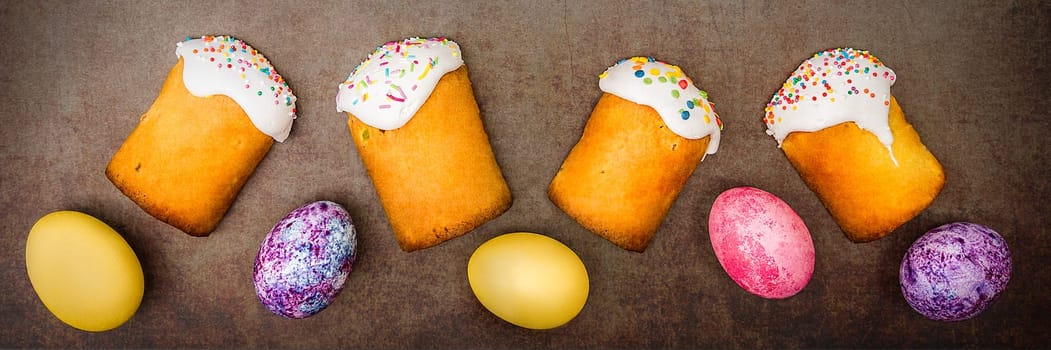 Easter cakes and Easter colored eggs on a dark background. Religious holiday of bright Easter.