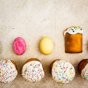 Easter cakes and Easter colored eggs on a beautiful textured background. Religious holiday of bright Easter.