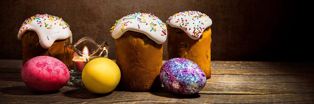 Easter cakes and Easter colored eggs on a dark background. Religious holiday of bright Easter.