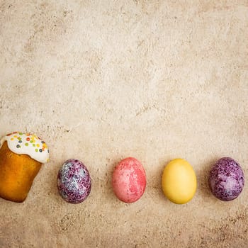 Easter cakes and Easter colored eggs on a beautiful textured background. Religious holiday of bright Easter.