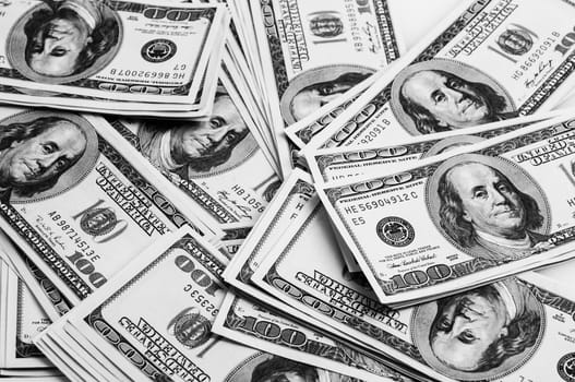 Cash of hundred dollar bills, dollar background image. One hundred US banknotes are scattered over the background. The style is black and white.