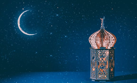 Ornamental Arabic lantern with crescent moon glowing at night. Festive greeting card for Muslim holy month Ramadan Kareem.