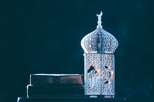 Ornamental Arabic lantern with with Holy Quran. Festive greeting card for Muslim holy month Ramadan Kareem.