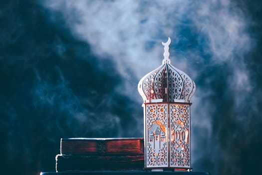 Ornamental Arabic lantern with with Holy Quran. Festive greeting card for Muslim holy month Ramadan Kareem.