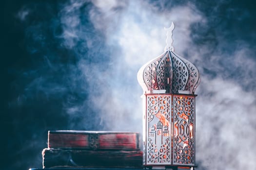 Ornamental Arabic lantern with with Holy Quran. Festive greeting card for Muslim holy month Ramadan Kareem.