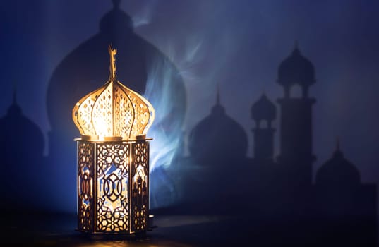 Ornamental Arabic lantern with crescent moon glowing at night. Festive greeting card for Muslim holy month Ramadan Kareem.