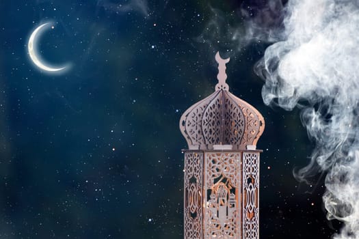Ornamental Arabic lantern with crescent moon glowing at night. Festive greeting card for Muslim holy month Ramadan Kareem.