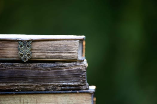 Literature, reading concept: banner or header image with stack of antique books against a dark background