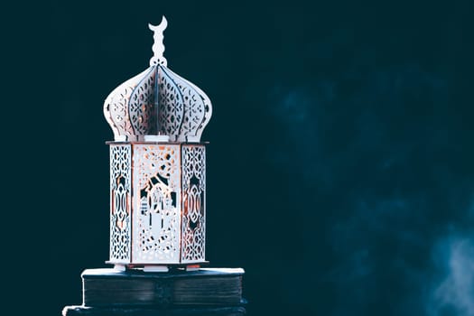Ornamental Arabic lantern with with Holy Quran. Festive greeting card for Muslim holy month Ramadan Kareem.