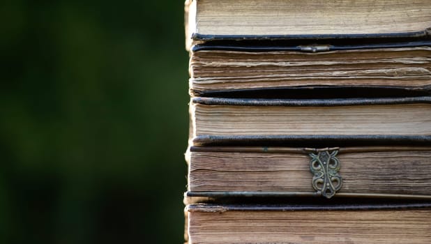 Literature, reading concept: banner or header image with stack of antique books against a dark background