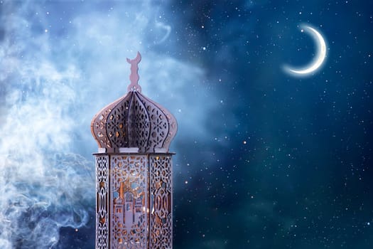 Ornamental Arabic lantern with crescent moon glowing at night. Festive greeting card for Muslim holy month Ramadan Kareem.
