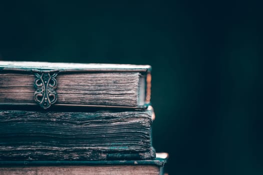 Literature, reading concept: banner or header image with stack of antique books against a dark background