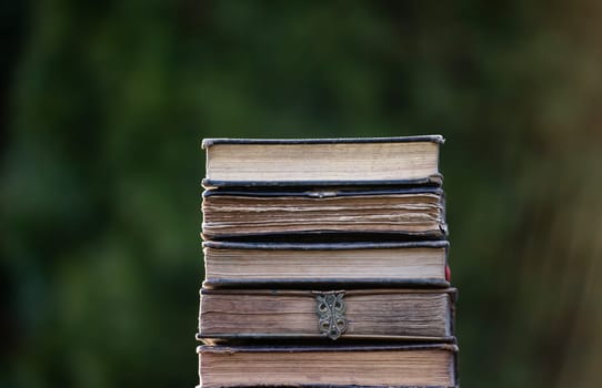 Literature, reading concept: banner or header image with stack of antique books against a dark background