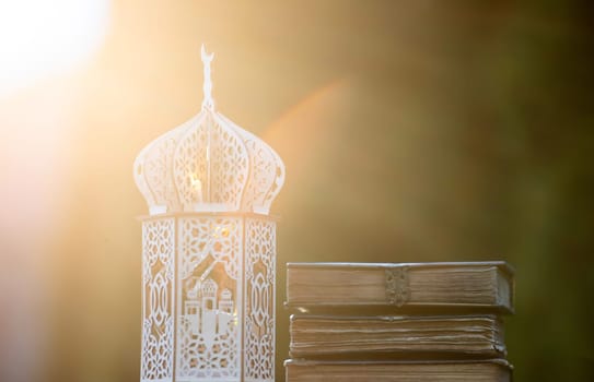 Ornamental Arabic lantern with with Holy Quran. Festive greeting card for Muslim holy month Ramadan Kareem.