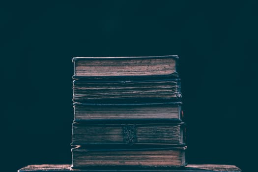 Literature, reading concept: banner or header image with stack of antique books against a dark background