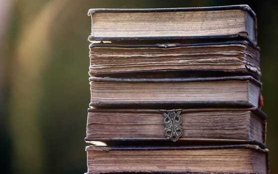 Literature, reading concept: banner or header image with stack of antique books against a dark background