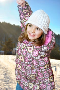 Happy little girl playing in snow