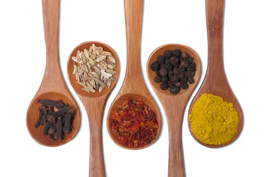 Various of spices in wooden spoon isolated over white