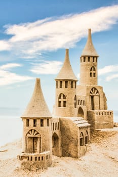 Sandcastle during a sunny day with blue sky background. Concept for summer, vacation, relax and fun.