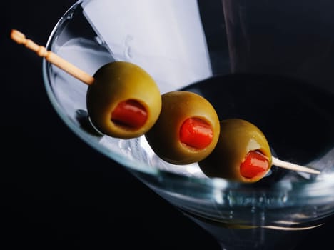 Three olives in martini glass