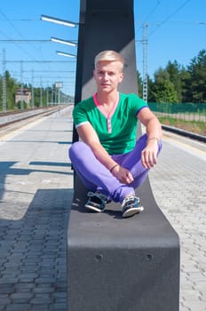 Handsome blond man in sunglasses sitting on the seat