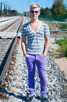 Good looking caucasian male outdoors in railway platform.