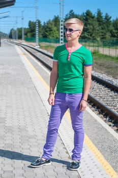 Good looking caucasian male outdoors in railway platform.