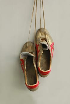Champion gold sneakers, hanging on laces