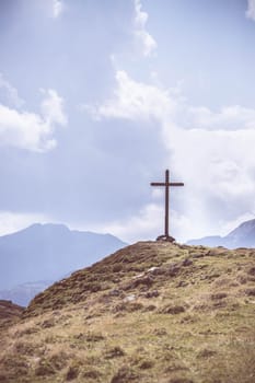 Peak with wooden summit cross in the Austrian mountains