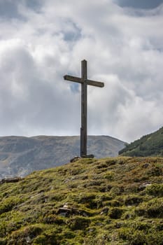 Peak with wooden summit cross in the Austrian mountains