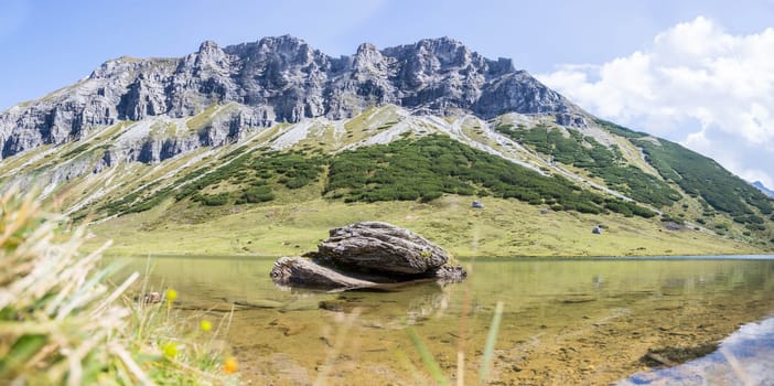 Lake with clear water in the foreground, rugged mountains in the background