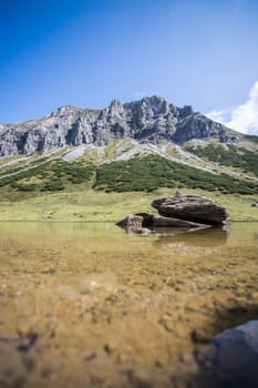 Lake with clear water in the foreground, rugged mountains in the background