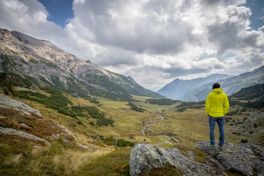 Male mountain climber with backpack is enjoying the view