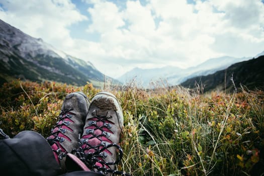 Cut out of a woman in hiking boots who is enjoying the idyllic mountain landscape