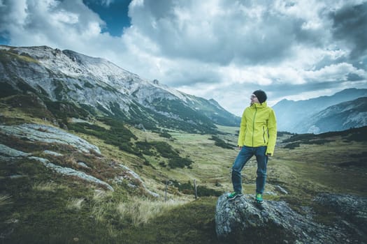 Male mountain climber with backpack is enjoying the view