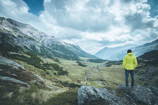 Male mountain climber with backpack is enjoying the view