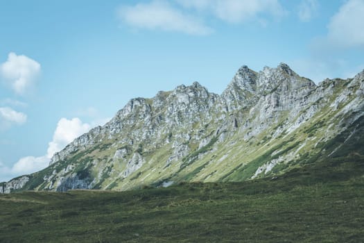 Picture of rugged mountains in the alps, blue sky with clouds