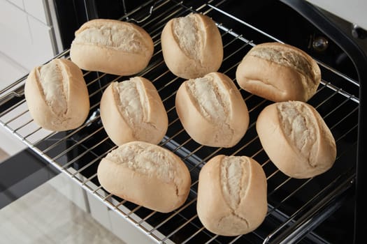 From above of half baked roll buns placed on glide rack of modern oven
