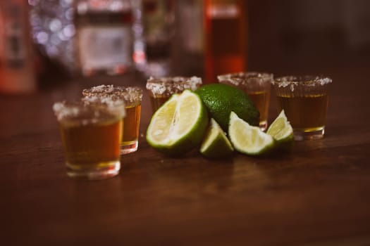 tequila , lime and salt on wooden table selective focus