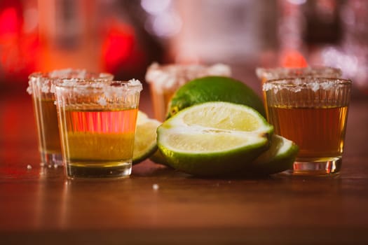 tequila , lime and salt on wooden table selective focus